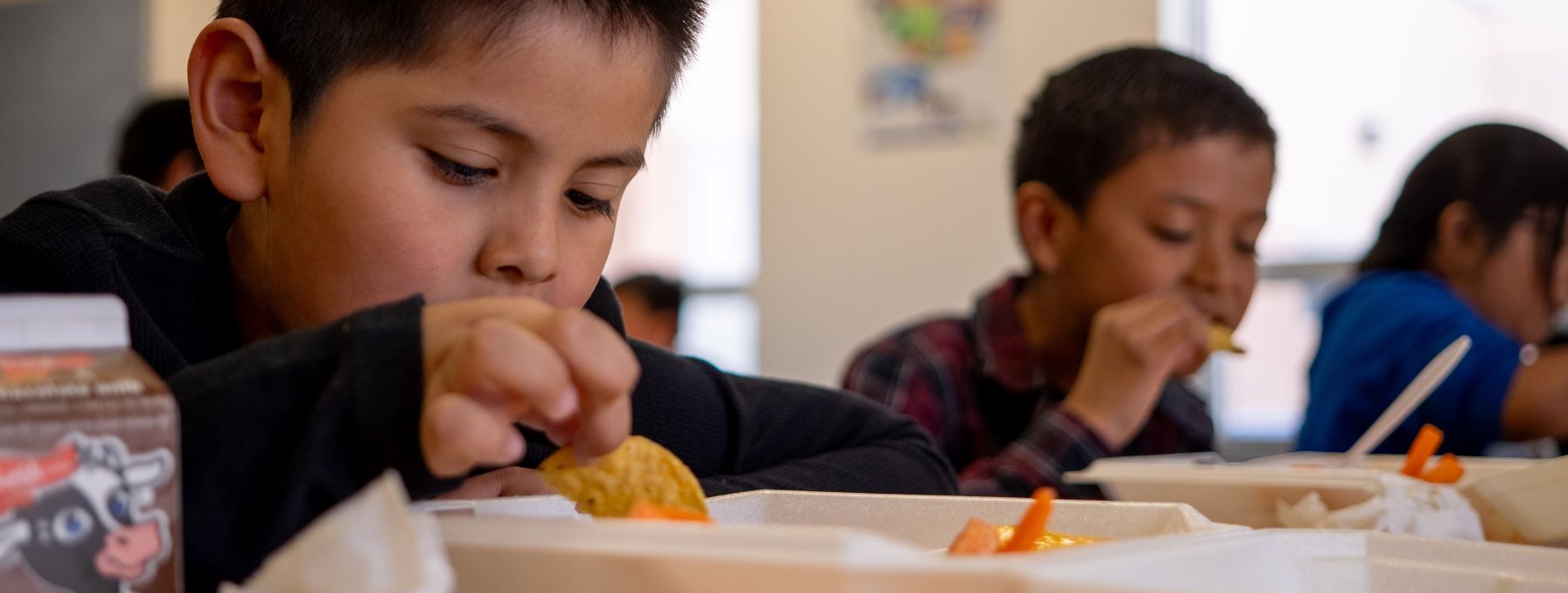 Students eating their lunch in the cafeteria.