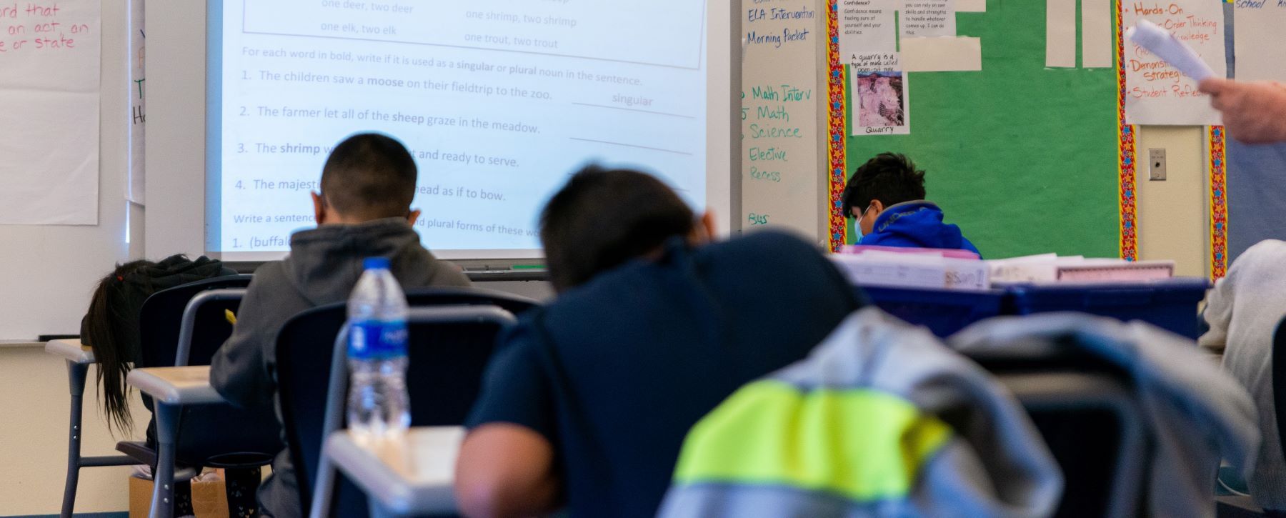 students sitting at their desks working on assignment in class