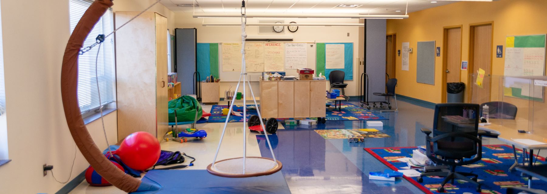 A classroom with a swing and toys, providing a playful and interactive learning environment for children.